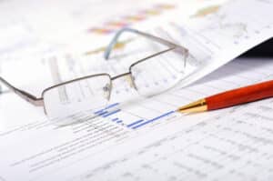 glasses and pen on papers with charts and diagrams - tax accounting services