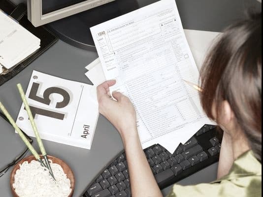 woman filling out 1040 tax form - certified accountant
