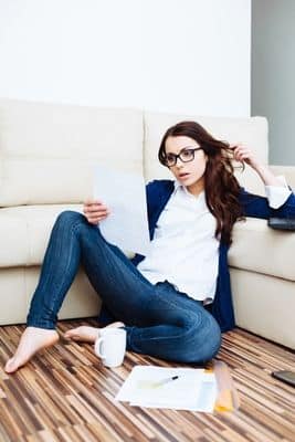 woman with glasses sitting on floor looking at papers - Long Island accountants